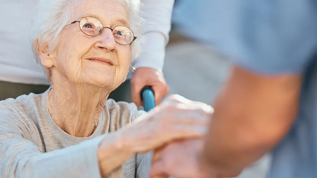 Seniorin lächelt Mitarbeiter zu